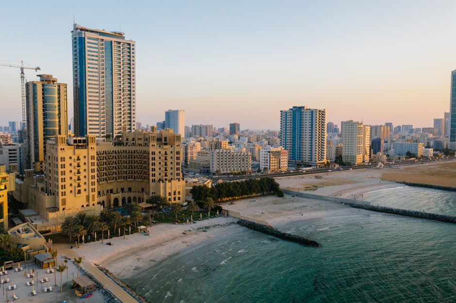 services-01 Explore the stunning aerial view of Ajman's urban coastal landscape, captured at sunset.